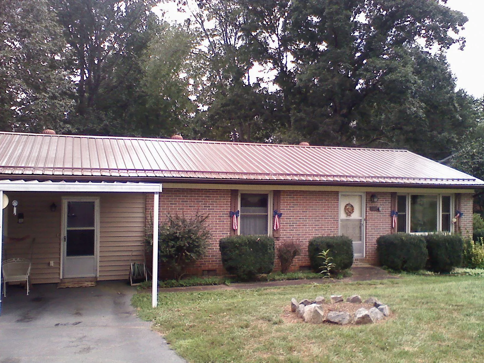Bronze metal roof and carport on a brick ranch home — Roof Repair work by our crew in Fort Myer