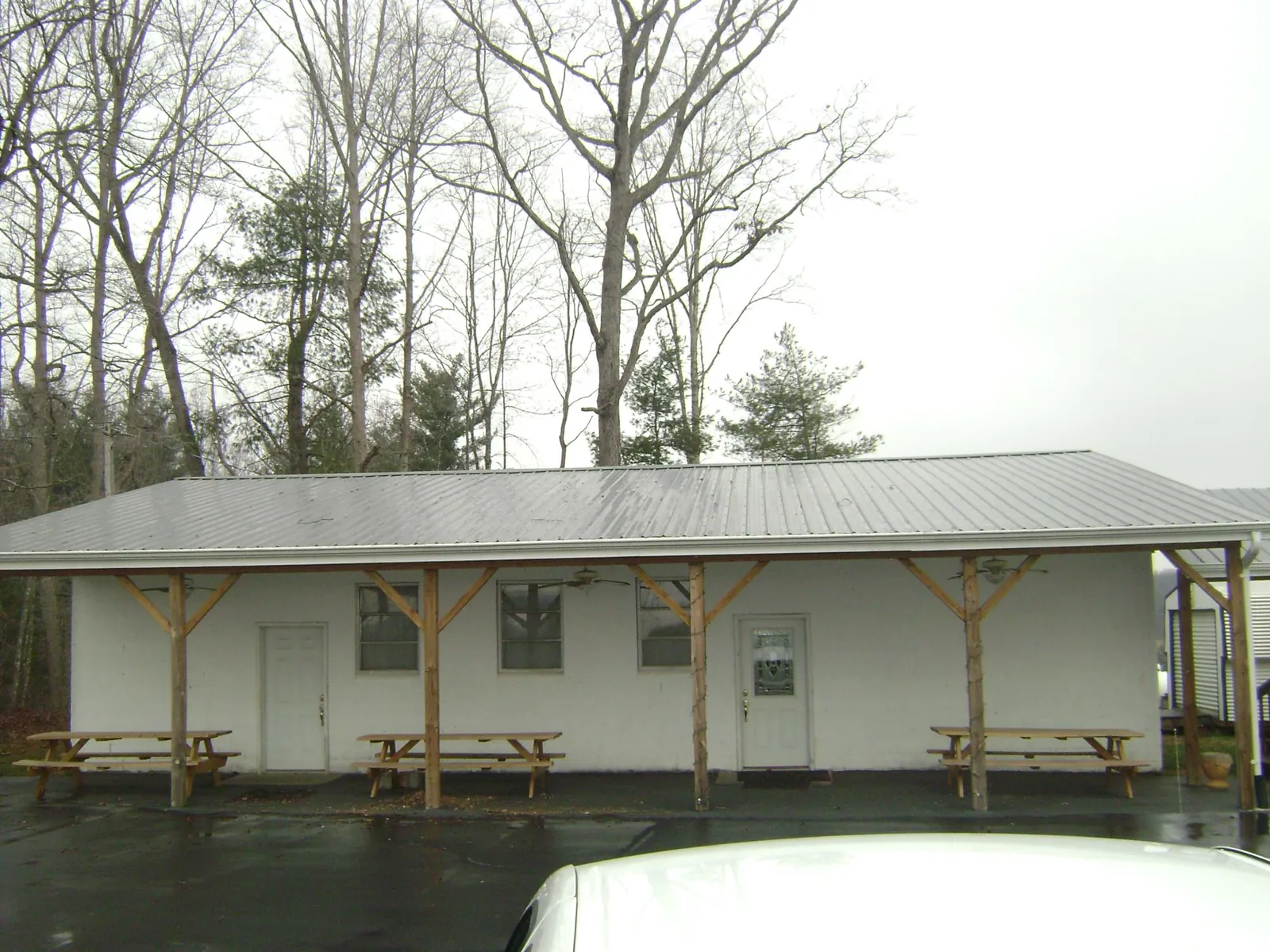Gray metal roof over a block building with a timber post porch in Fort Myer